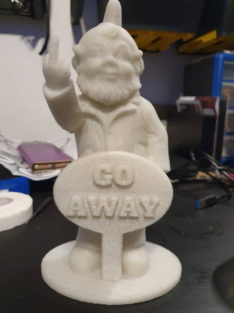 White statue of gnome holding 'Go Away' sign.