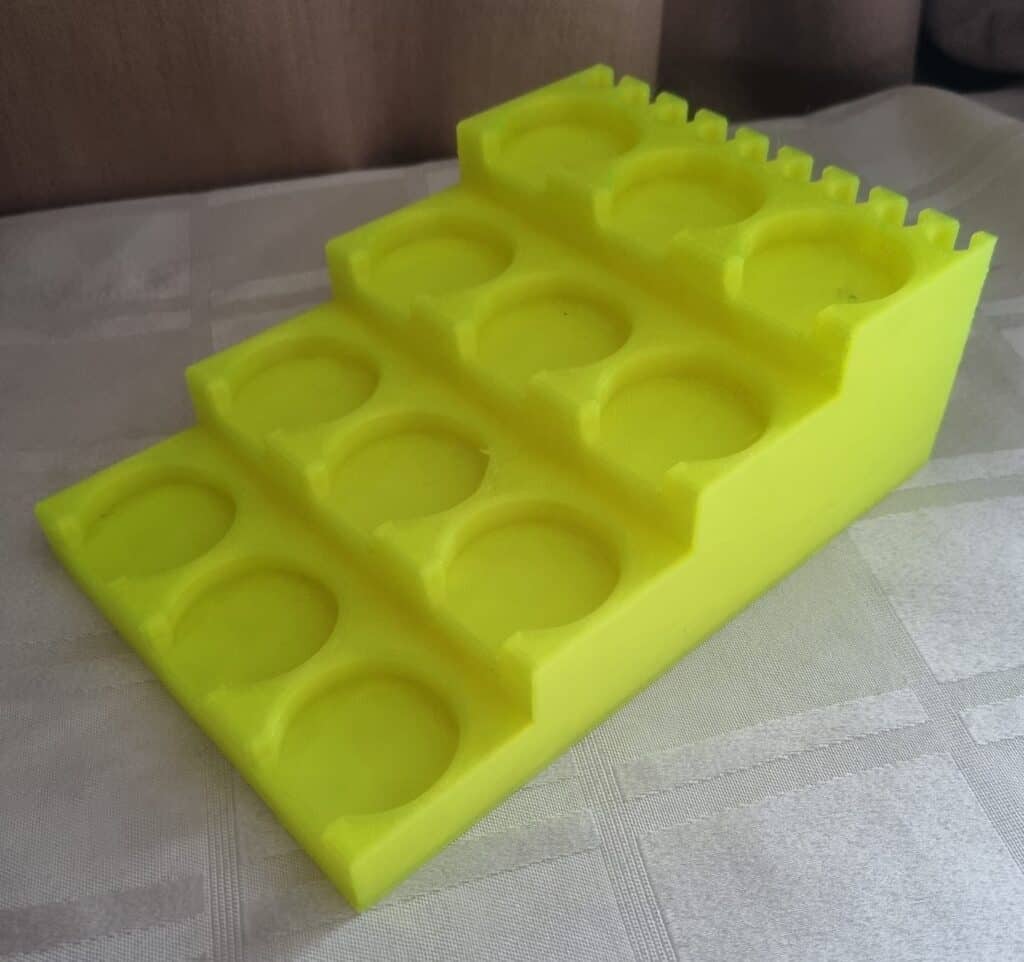 Yellow silicone ice cube tray on tablecloth.