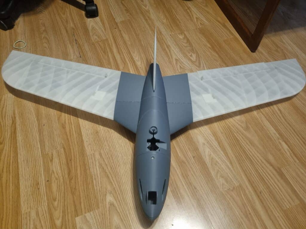 Model glider on wooden floor indoors.