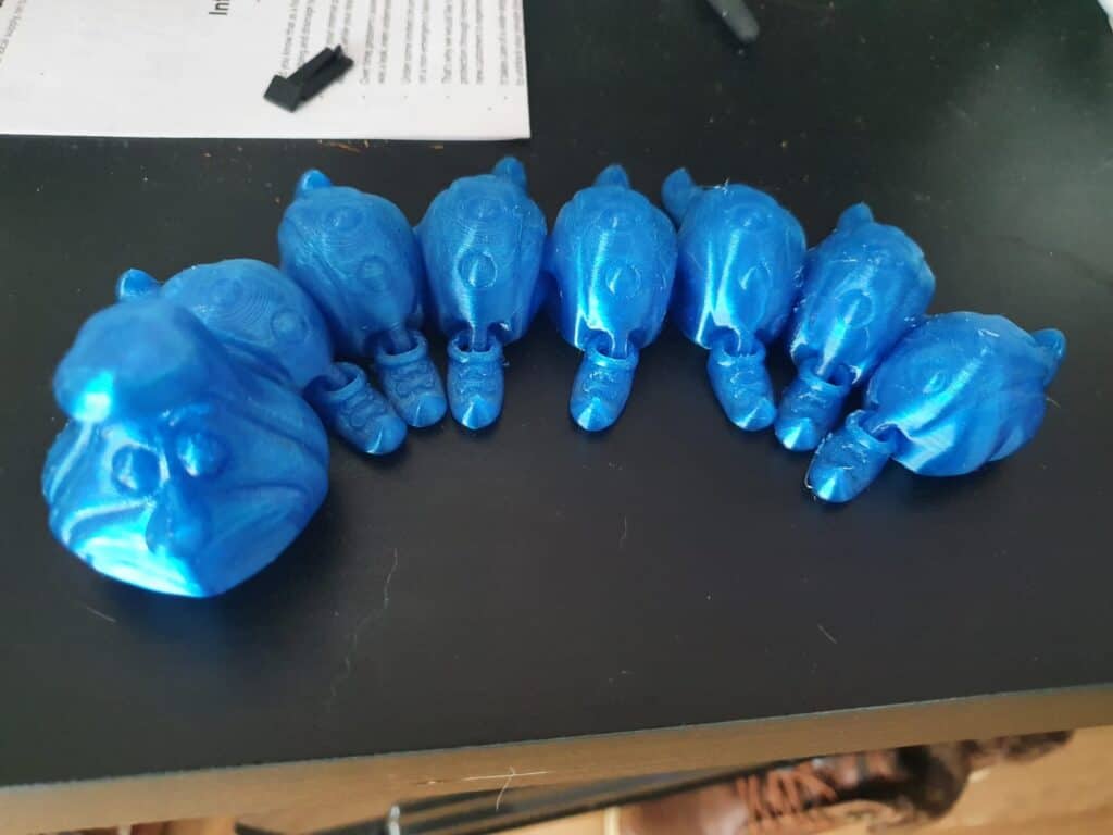 Blue 3D-printed fantasy creature figurines on table.