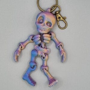 Iridescent skeleton keychain on grey background