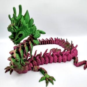 Green and magenta articulated dragon figurine on white background