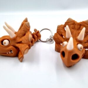 Two brown triceratops dinosaur keyrings on white background