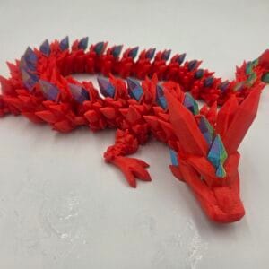 Red articulated 3D-printed dragon with multicoloured spikes